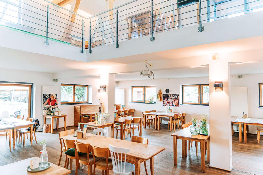 Heller Restaurant-Raum mit Holztischen bei Gut Hügle